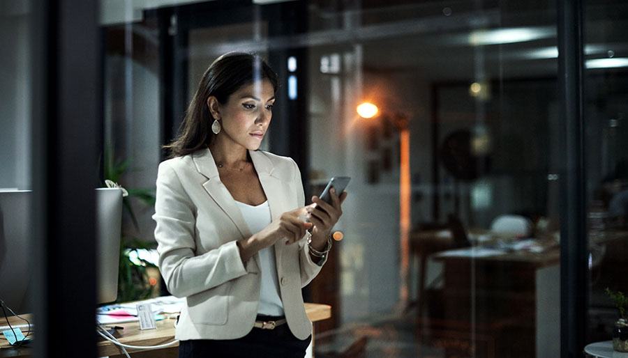 Shot of a young businesswoman using her phone at work